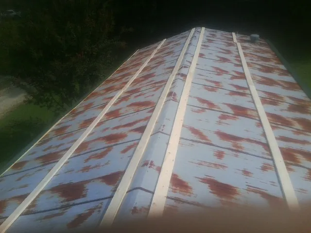 Rusted metal roof panels with new wood purlins before replacement — Storm Damage Roof Repair in Kemmerer by Roofing Brothers