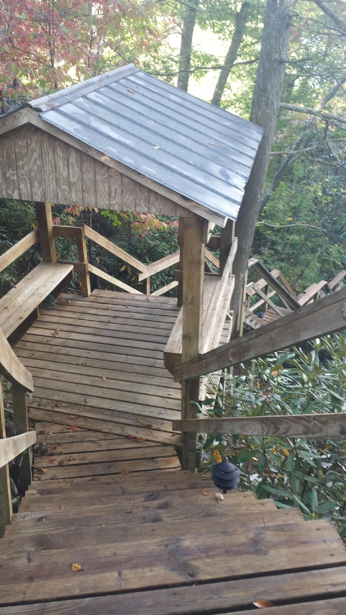 Metal roofed shelter over wooden steps on a wooded walkway — Skylight Repair & Installation work by our crew in Kemmerer